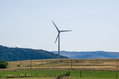 Windmill on field against sky