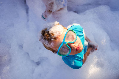 High angle portrait of boy standing in soap sud 