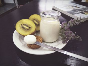 Close-up of fruits and drink in plate on table