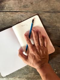 High angle view of person reading book on table