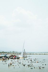 Group of people on beach against sky