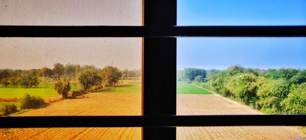 Scenic view of field seen through window