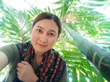 Portrait of young woman with palm leaves