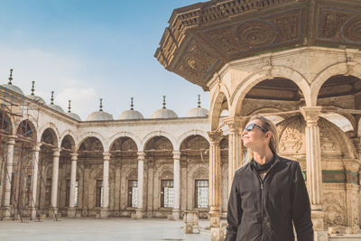 Woman standing at historical building