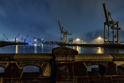 Illuminated commercial dock against sky at dusk