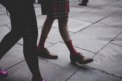 Low section of women standing on tiled floor