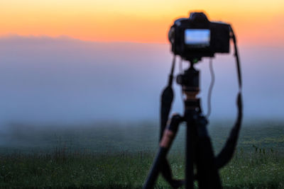 Man photographing on landscape during sunset