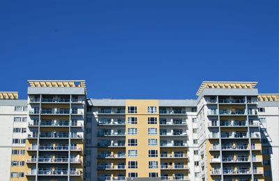 Low angle view of buildings against clear blue sky