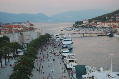 High angle view of boats in harbor by buildings in city