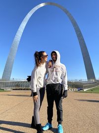 Low angle view of woman and man standing against sky smiling and happy