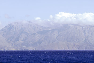 Scenic view of sea and snowcapped mountains against sky