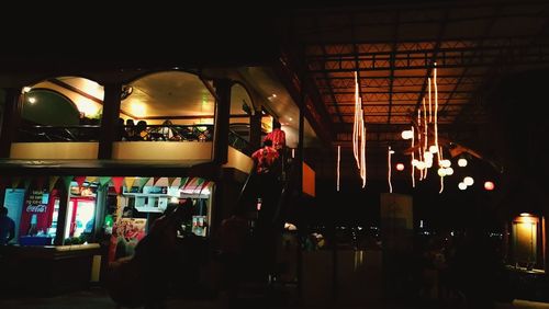 People in illuminated market at night