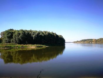 Scenic view of lake against clear blue sky