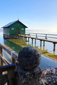 Building by sea against clear blue sky