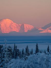 Scenic view of snowcapped mountains against sky during sunset