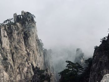 Low angle view of rocky mountains against sky