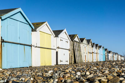 Low angle view of abandoned house against clear blue sky