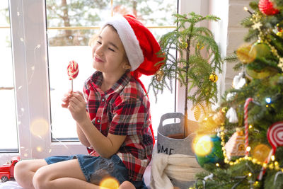 Portrait of girl decorating christmas tree at home