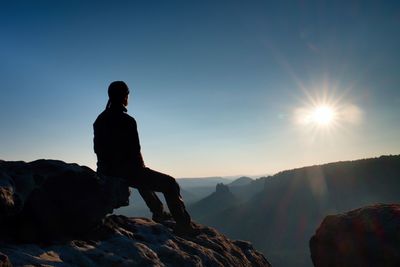 Hiker take a rest in nature. mountain summit above forest in valley. traveling in european parks.