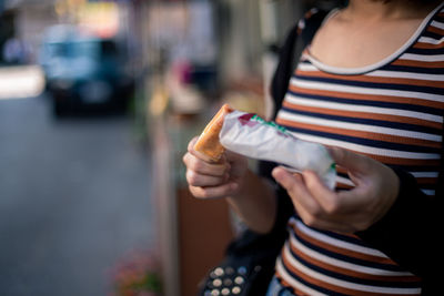 Midsection of woman holding ice cream