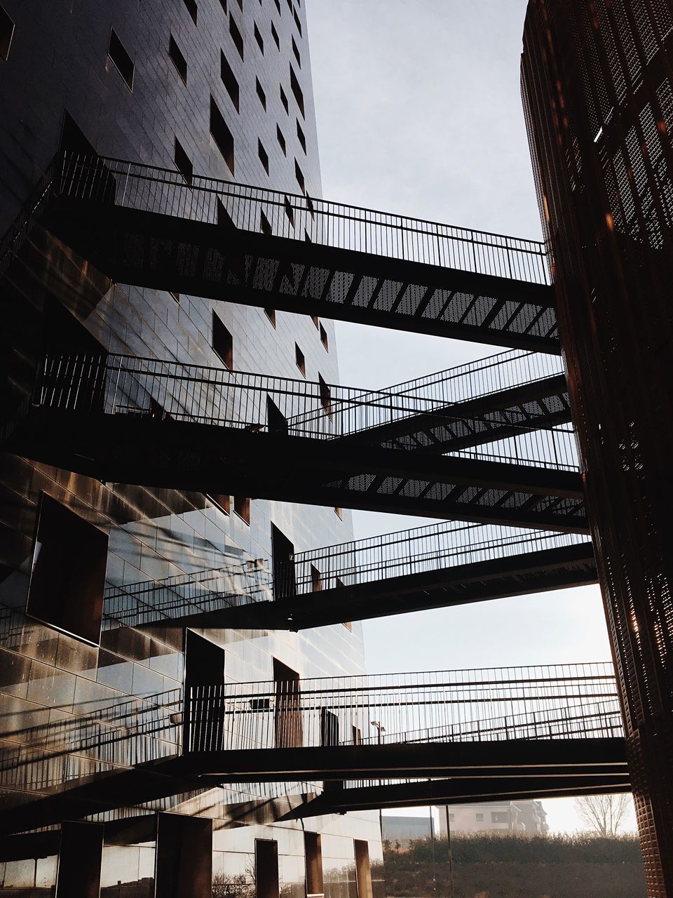 LOW ANGLE VIEW OF BRIDGE IN CITY AGAINST SKY