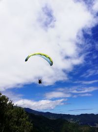 Low angle view of person paragliding against sky