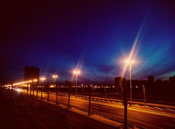 Illuminated railing against sky at night
