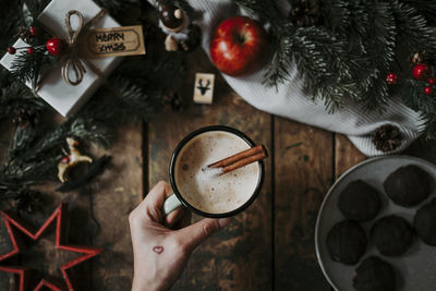 High angle view of hand holding coffee on table