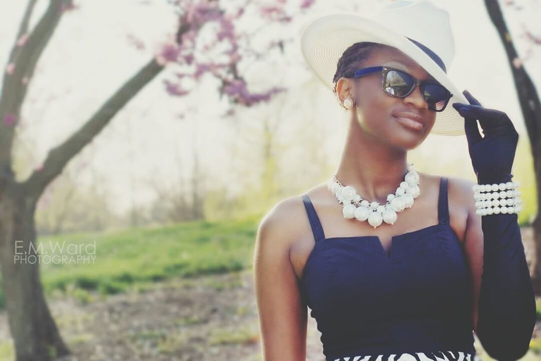 young adult, lifestyles, person, leisure activity, young women, looking at camera, portrait, sunglasses, casual clothing, front view, smiling, focus on foreground, tree, happiness, standing, three quarter length, waist up