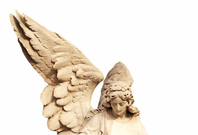 Low angle view of angel statue against white background