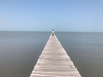 Pier over sea against clear sky