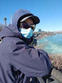 Portrait of man standing by sea against clear sky