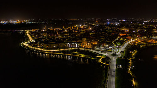 High angle view of illuminated city by river at night