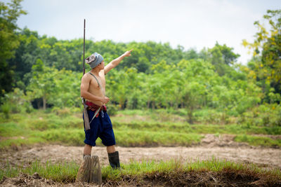 Full length of shirtless man standing on land
