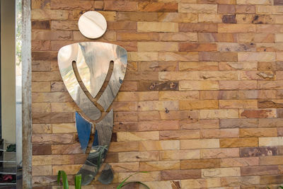 Rear view of female sculpture on brick wall