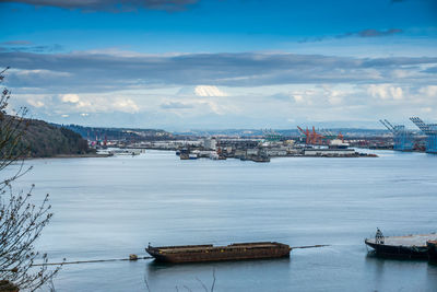 Clouds partially cover mount rainier which towers over the port of tacoma.