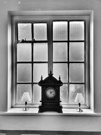 Close-up of clock on window at home