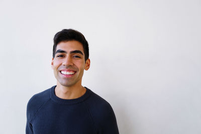 Portrait of smiling young man against white background