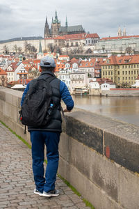 Rear view of man standing against buildings in city