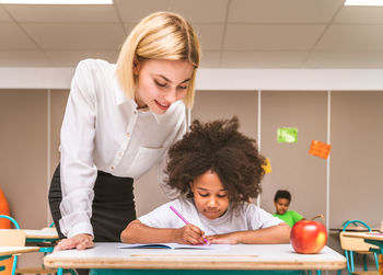 Teacher teaching student at classroom