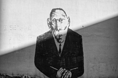 Portrait of young man standing against wall