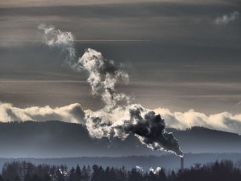 Smoke emitting from chimney against sky