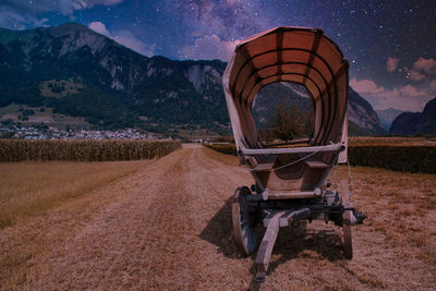 Horse cart on field against mountain range