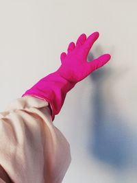 Close-up of woman hand against pink wall