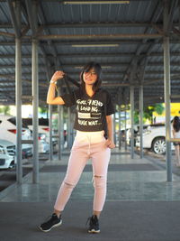 Full length portrait of woman standing in basement