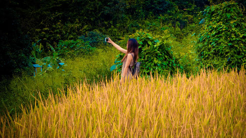 Woman taking selfie on field