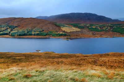 Scenic view of lake and mountains against sky