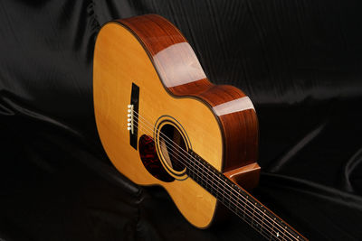 Close-up of guitar on bed