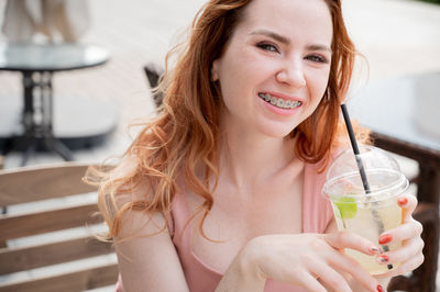 Portrait of young woman drinking glass