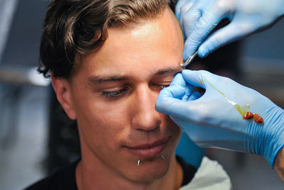 Close-up portrait of young man holding hands